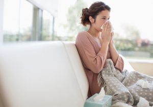 couch-woman-sneezing-blanket