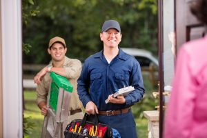 two-technicians-ladder-tools-at-door