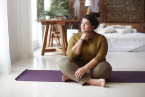 plus-size-women-looking-out-window-of-bedroom