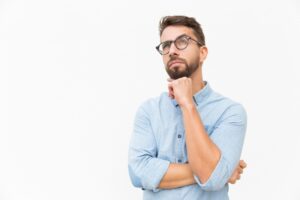 man-with-glasses-looks-thoughtful-hand-under-chin